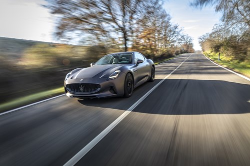 A Maserati GranTurismo Folgore on a road with trees on either side
